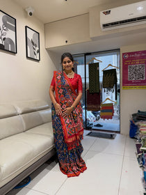 Blue and red silk saree styled with red blouse standing view
